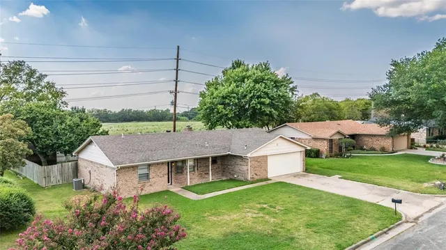 a aerial view of a house with a yard and potted plants