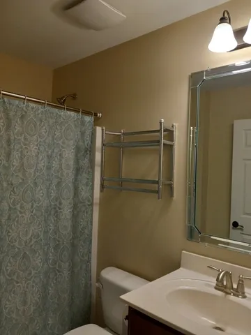 a bathroom with a sink mirror vanity and toilet