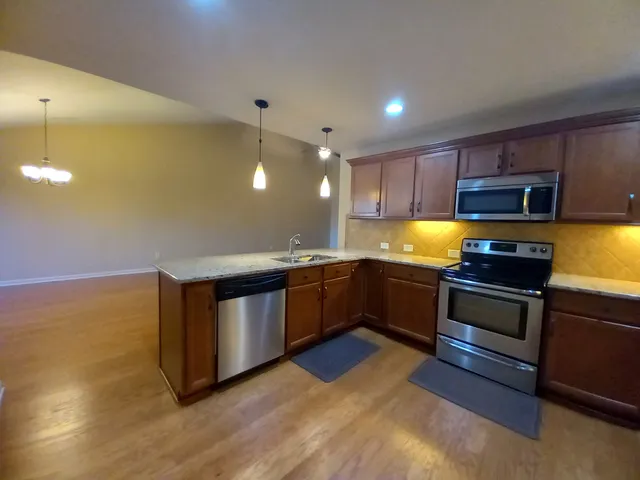 a kitchen with stainless steel appliances granite countertop a stove a sink and a refrigerator