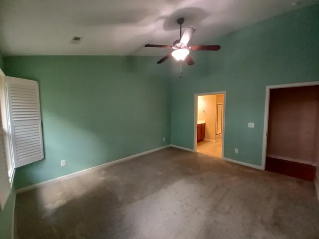 a view of an empty room with window and fan