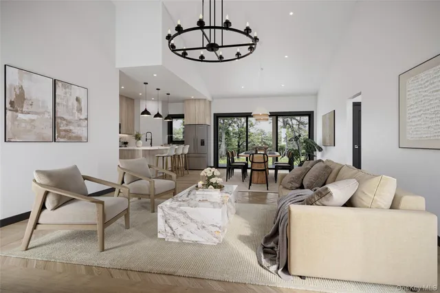a living room with furniture a chandelier and a dining table