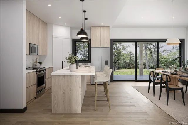 a view of a kitchen with kitchen island and stainless steel appliances