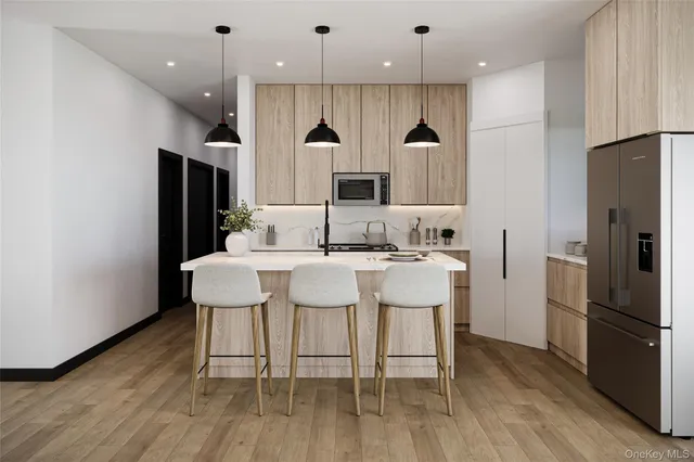 a kitchen with kitchen island granite countertop a sink and a refrigerator