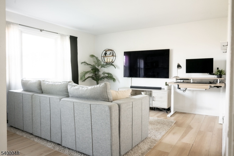 300 Wilson Road, Unit 24D Springfield, NJ 07081 - Photo 4 of 11 a living room with furniture and a flat screen tv