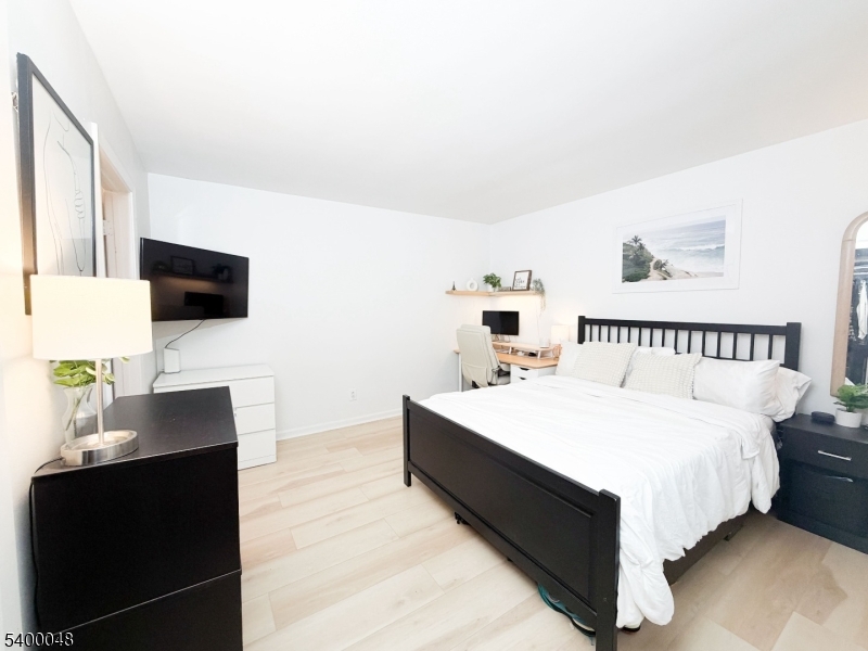 300 Wilson Road, Unit 24D Springfield, NJ 07081 - Photo 6 of 11 a spacious bedroom with a bed and a flat screen tv