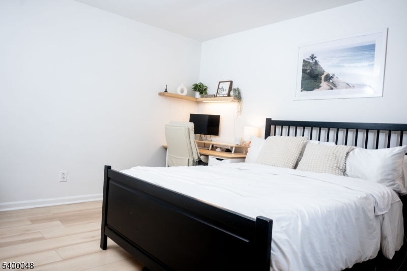 300 Wilson Road, Unit 24D Springfield, NJ 07081 - Photo 7 of 11 a room with a bed and a night stand