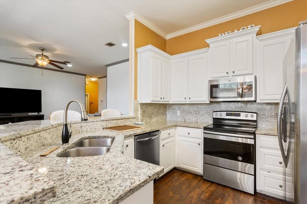 736 Tahoe Trail Hewitt, TX 76643 - Photo 11 of 30 Kitchen with crown molding, stainless steel appliances, backsplash, light stone counters, and white cabinets