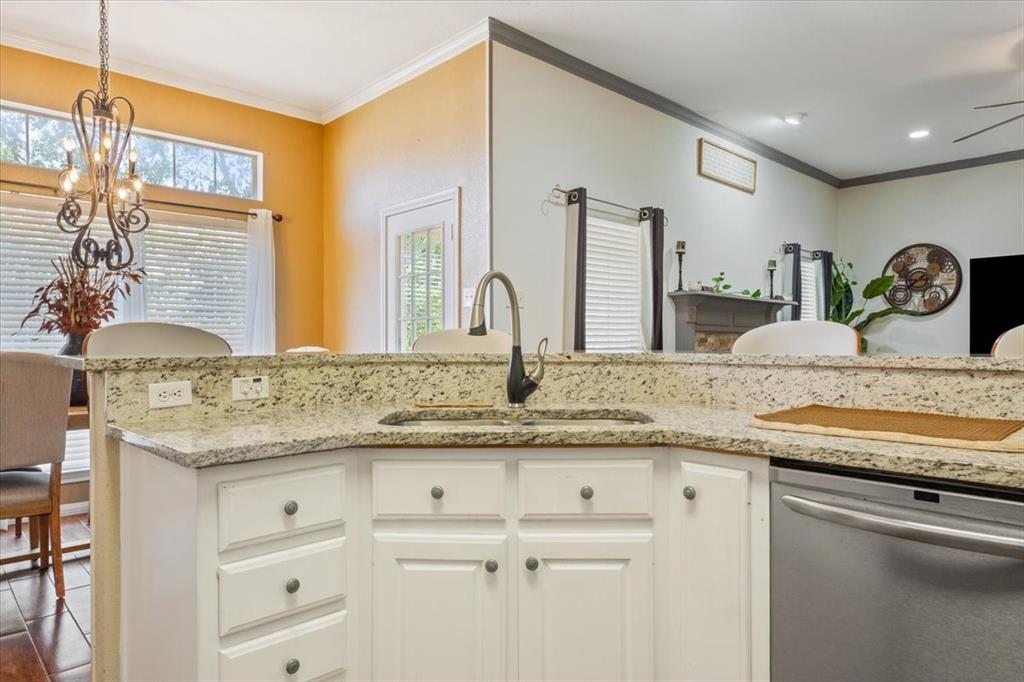 736 Tahoe Trail Hewitt, TX 76643 - Photo 13 of 30 Kitchen featuring white cabinets, stainless steel dishwasher, light stone countertops, ornamental molding, and pendant lighting