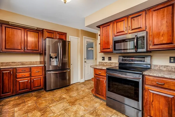 a kitchen with stainless steel appliances granite countertop a refrigerator stove and sink