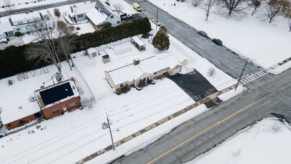 an aerial view of residential house with parking and mountain view