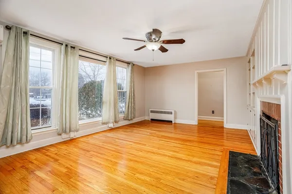 a view of an empty room with a fireplace and a window