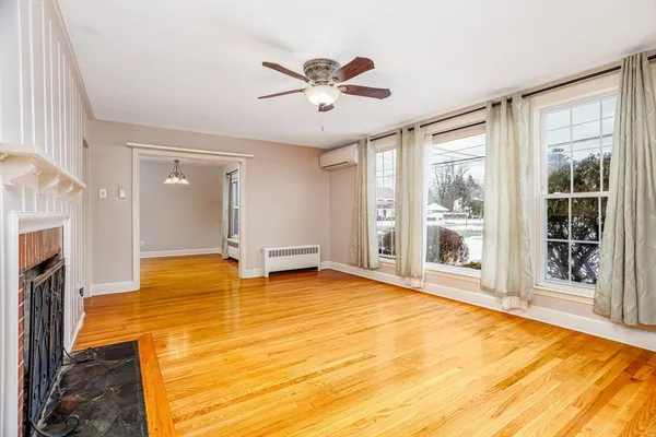 a view of an empty room with a fireplace and a window