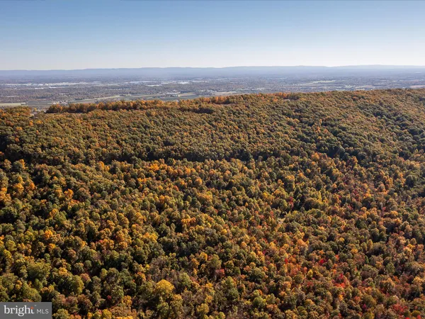 an aerial view of house with yard and mountain view in back
