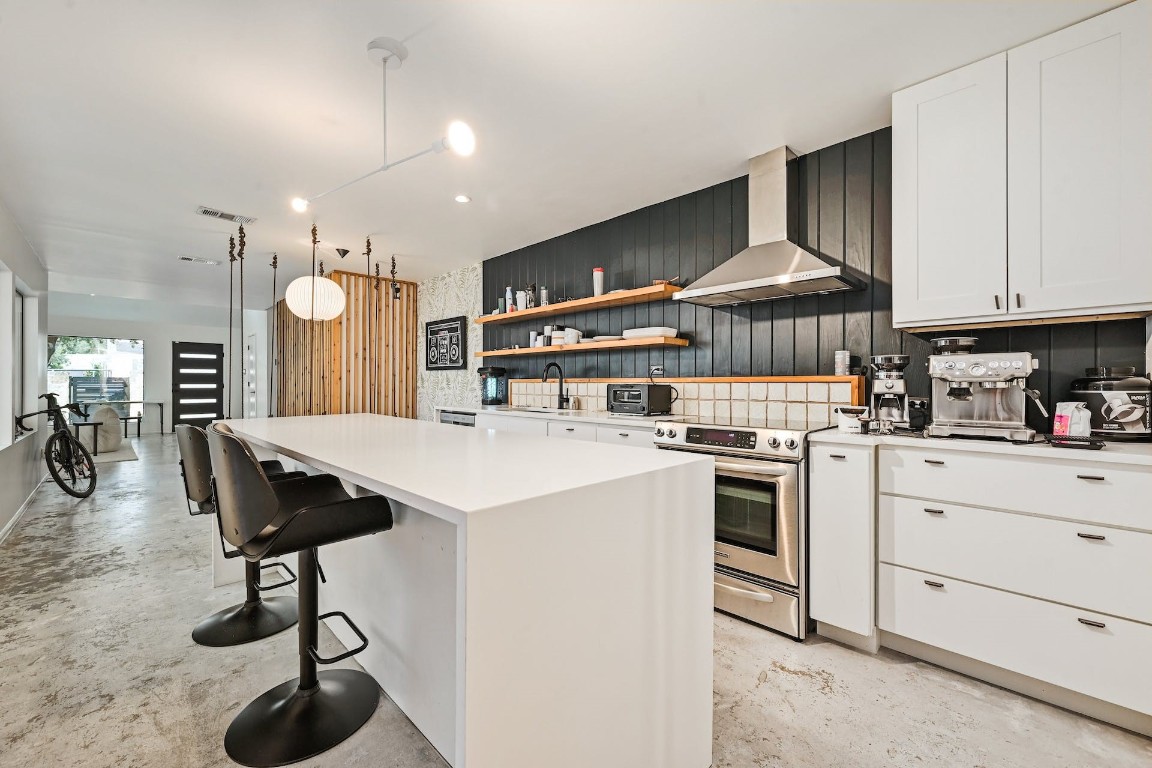 a kitchen with stainless steel appliances kitchen island a cabinets and a chandelier