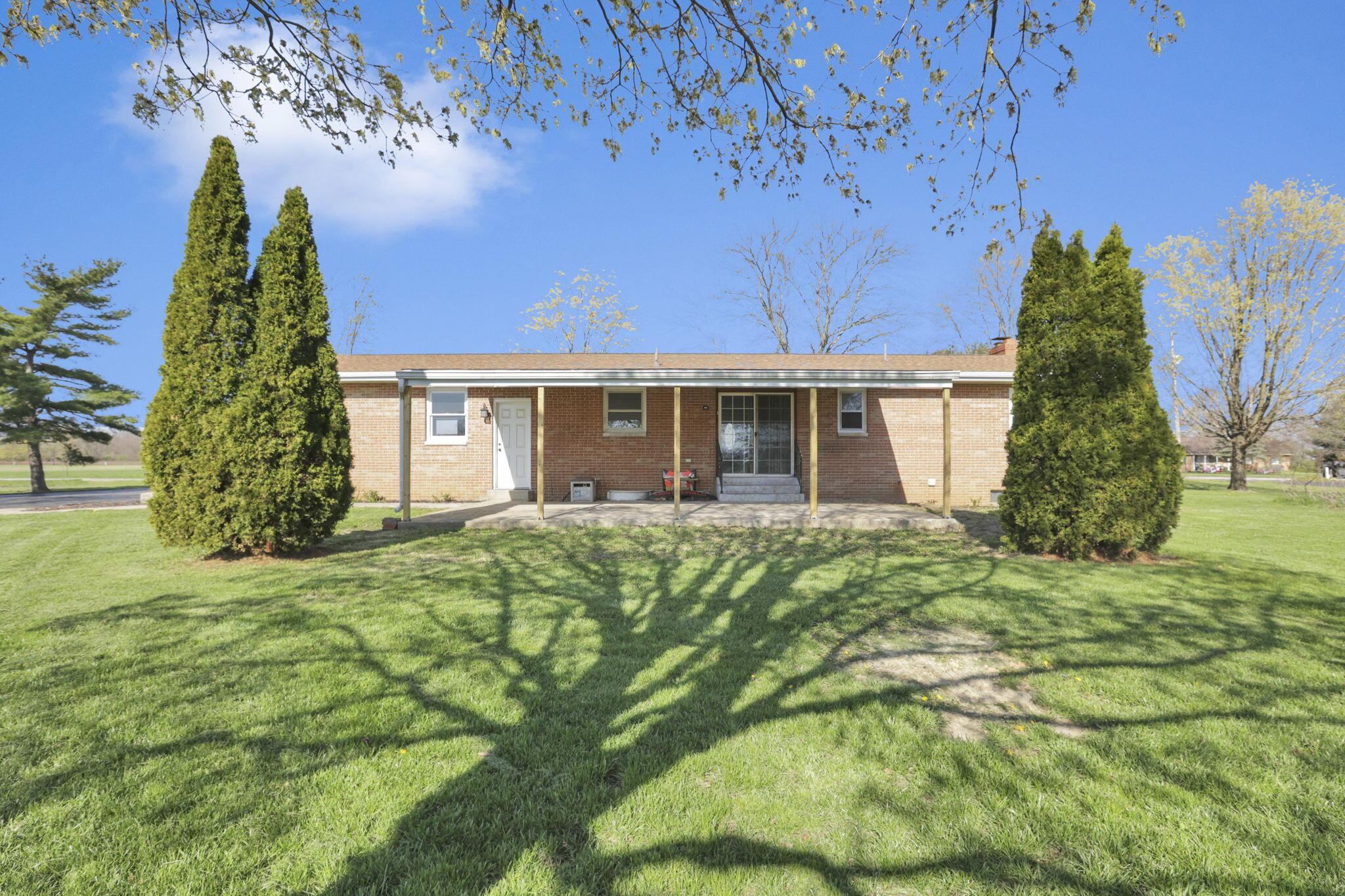 7974 Braun Road Groveport, OH 43125 - Photo 6 of 29 Brick exterior featuring a covered patio, expansive green lawn, and mature trees