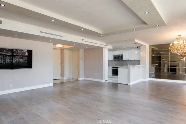 a view of a big room with wooden floor and windows