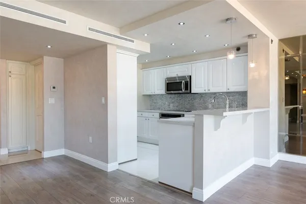 a kitchen with white cabinets a sink and stainless steel appliances