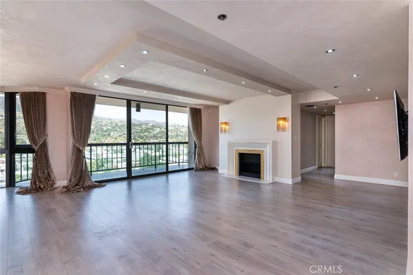 a view of an empty room with wooden floor and a floor to ceiling window