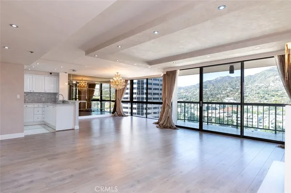 a view of empty room with wooden floor and a fireplace