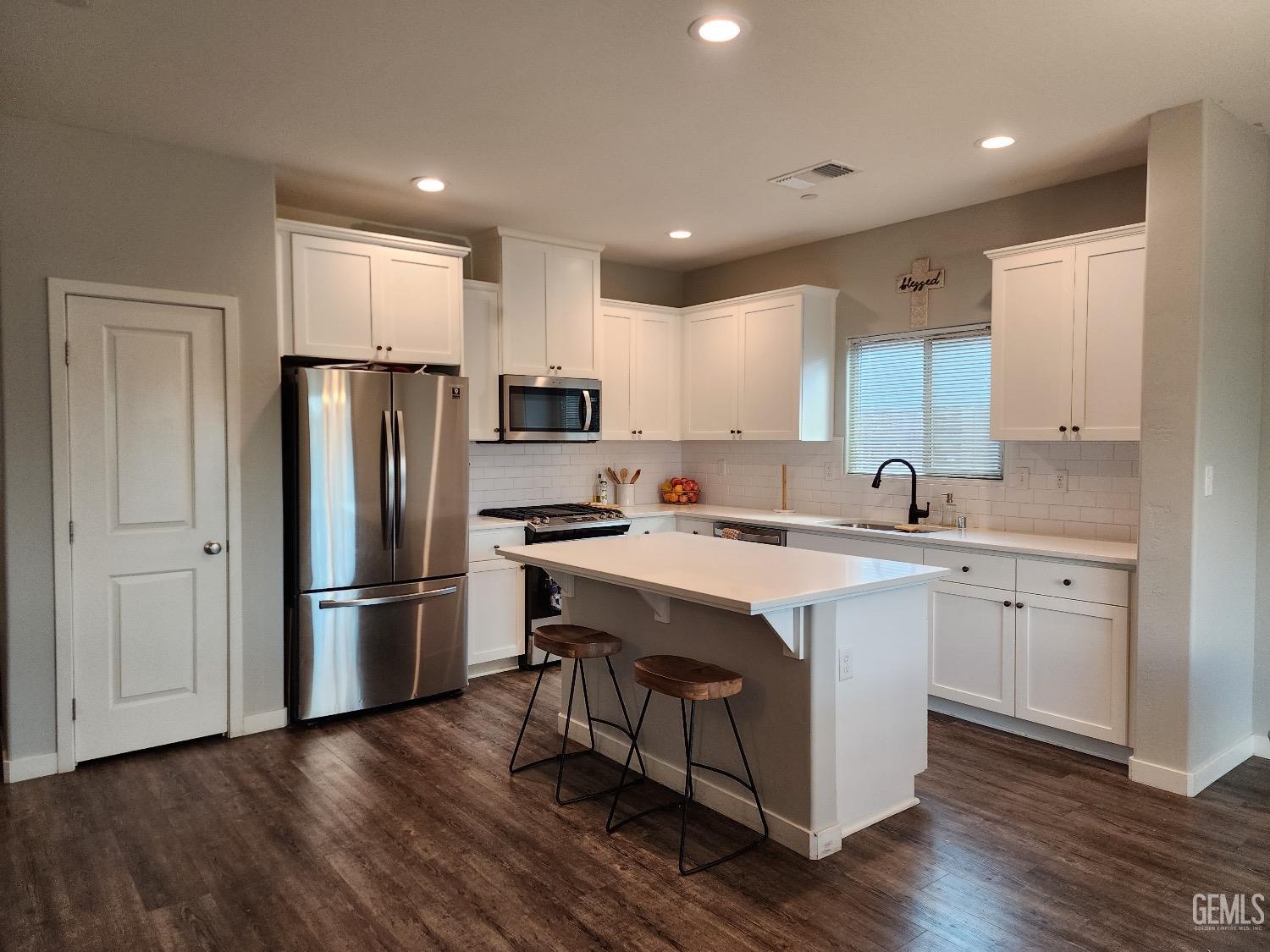 Undisclosed Address Bakersfield, CA 93307 - Photo 2 of 11 a kitchen with refrigerator cabinets wooden floor and a window