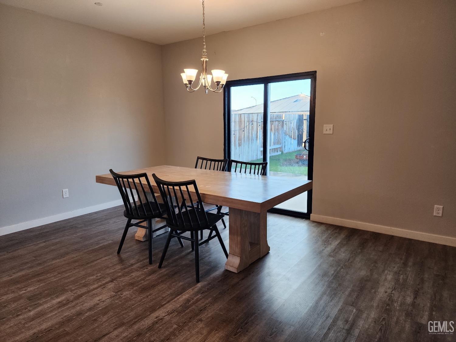 Undisclosed Address Bakersfield, CA 93307 - Photo 3 of 11 a dining room with furniture a chandelier and wooden floor