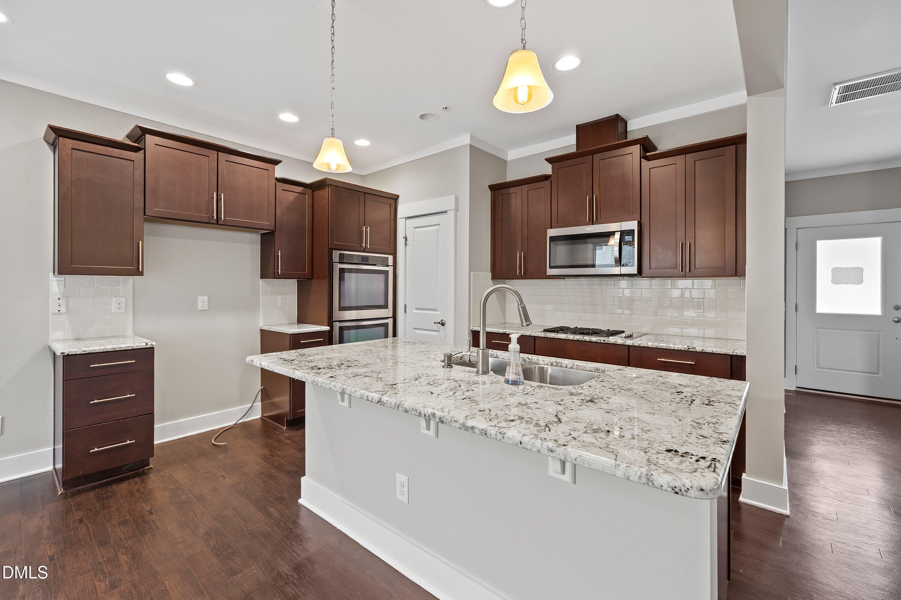 9903 Remedios Walk Raleigh, NC 27617 - Photo 15 of 53 a kitchen with stainless steel appliances granite countertop a sink refrigerator and microwave