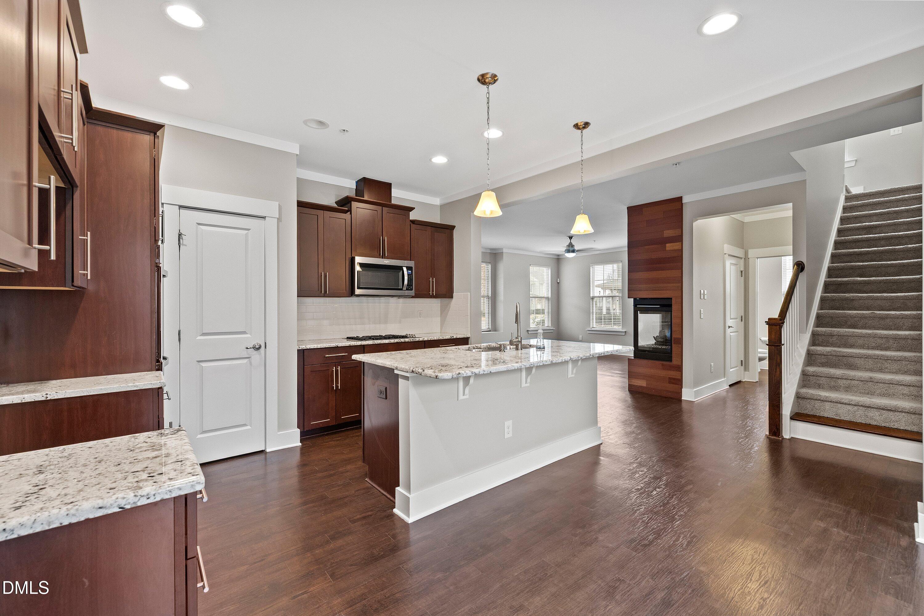 9903 Remedios Walk Raleigh, NC 27617 - Photo 17 of 53 a large kitchen with stainless steel appliances granite countertop a large counter top and wooden floors