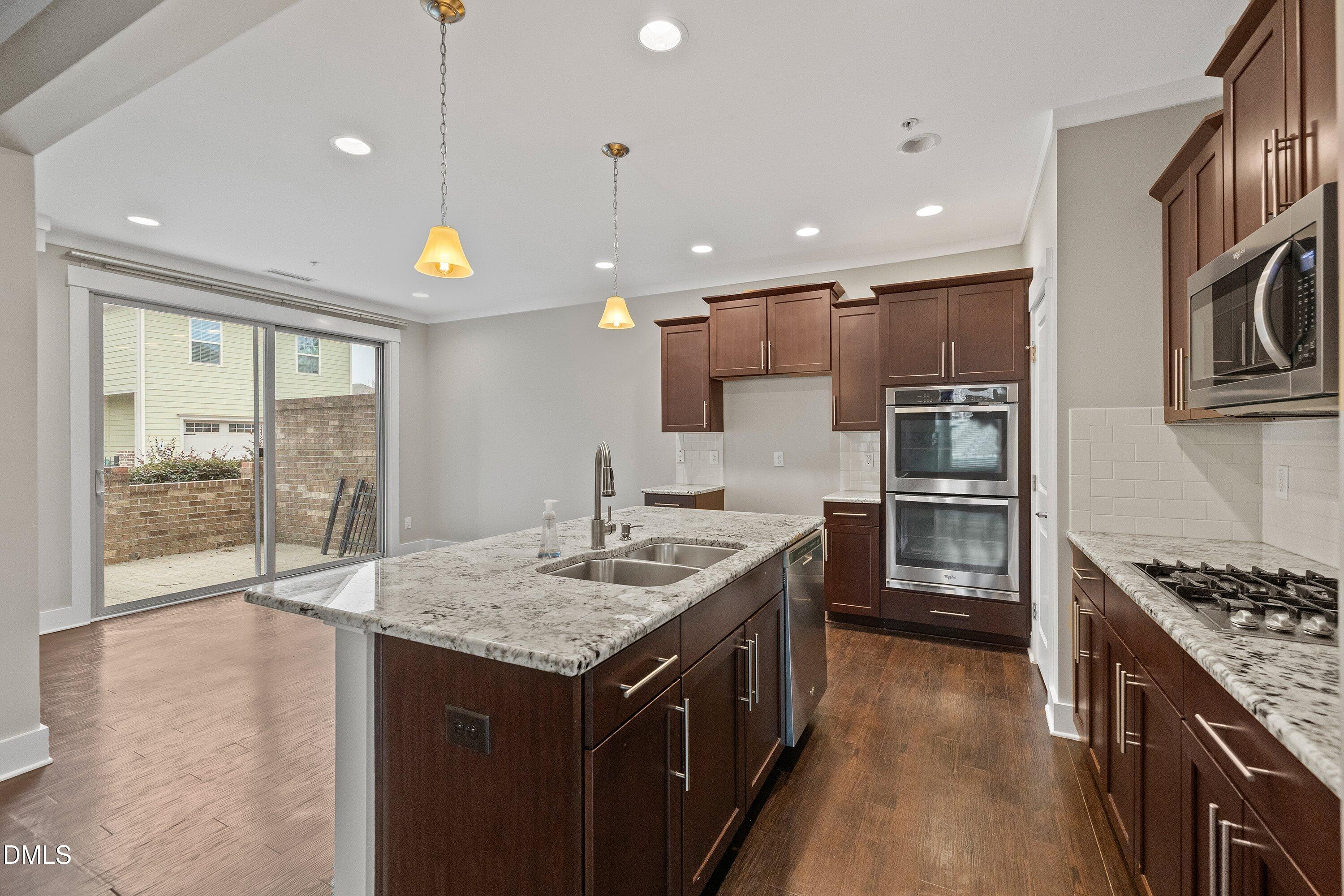 9903 Remedios Walk Raleigh, NC 27617 - Photo 18 of 53 a kitchen with granite countertop a sink stove and cabinets