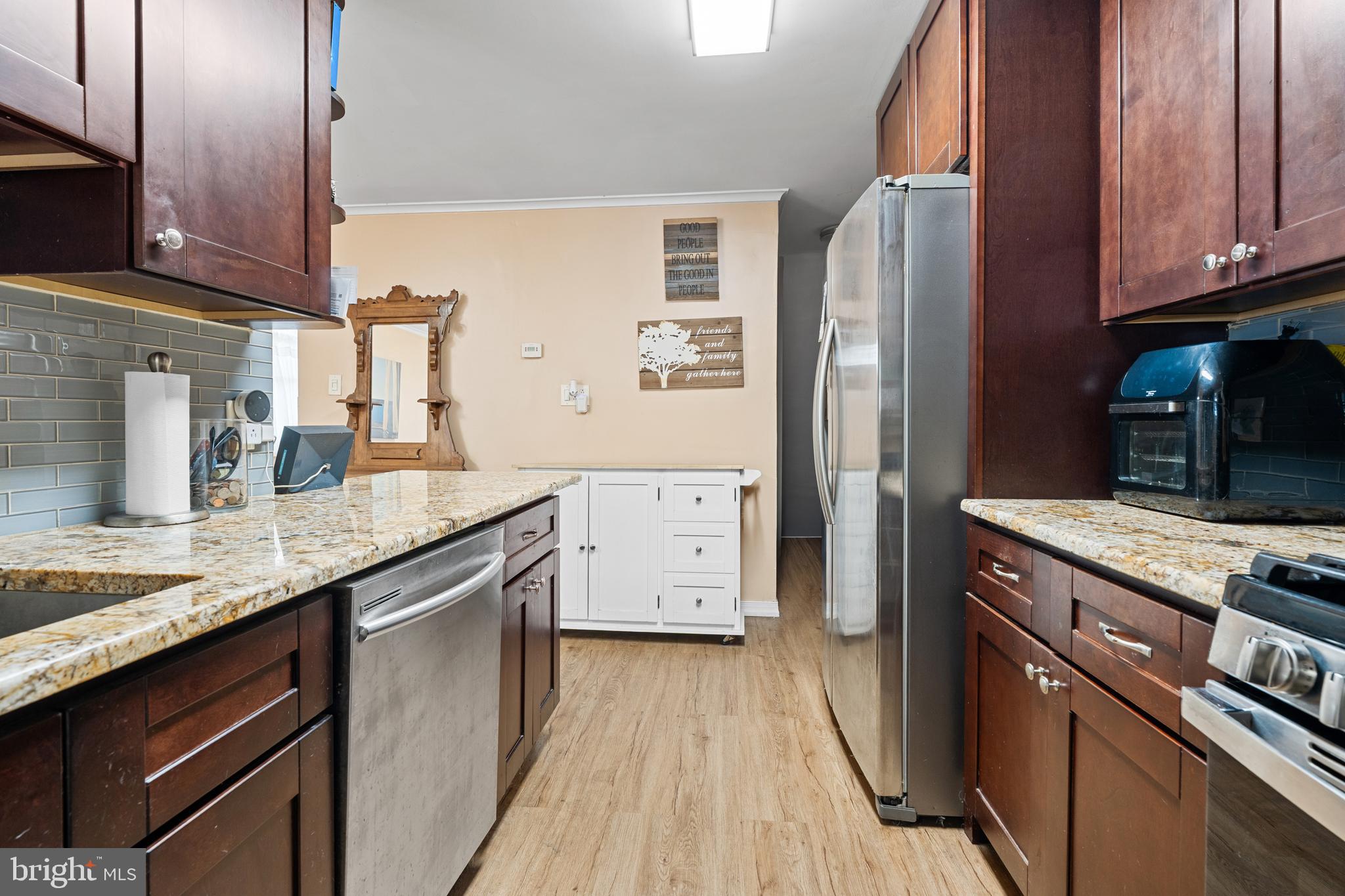 1614 Blackrock Road Swarthmore, PA 19081 - Photo 11 of 31 a kitchen with stainless steel appliances granite countertop a refrigerator a stove and a sink with wooden cabinets