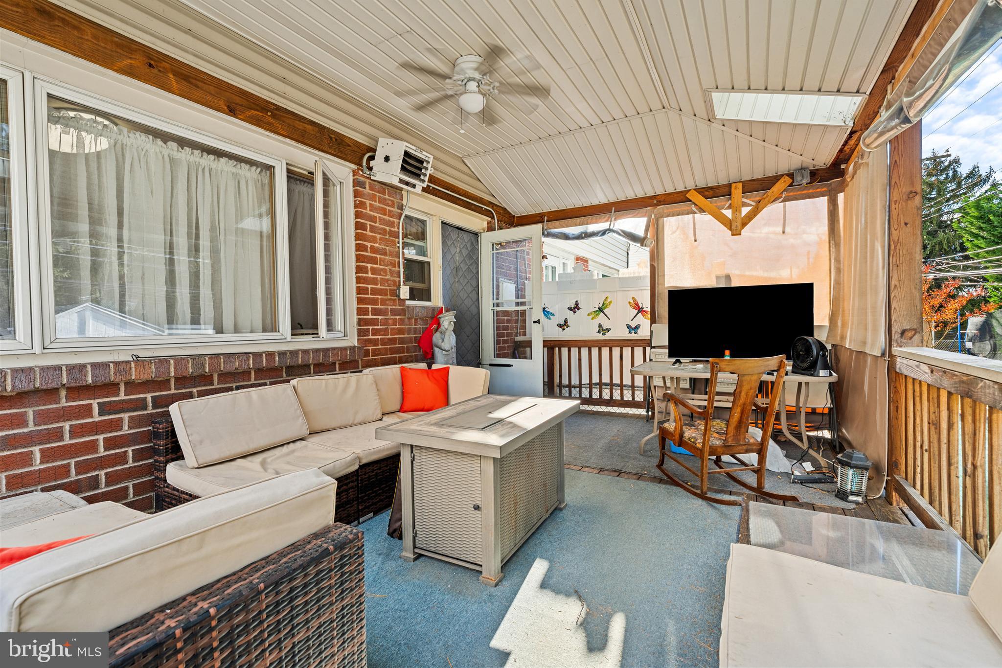 1614 Blackrock Road Swarthmore, PA 19081 - Photo 26 of 31 a living room with furniture a flat screen tv and a floor to ceiling window
