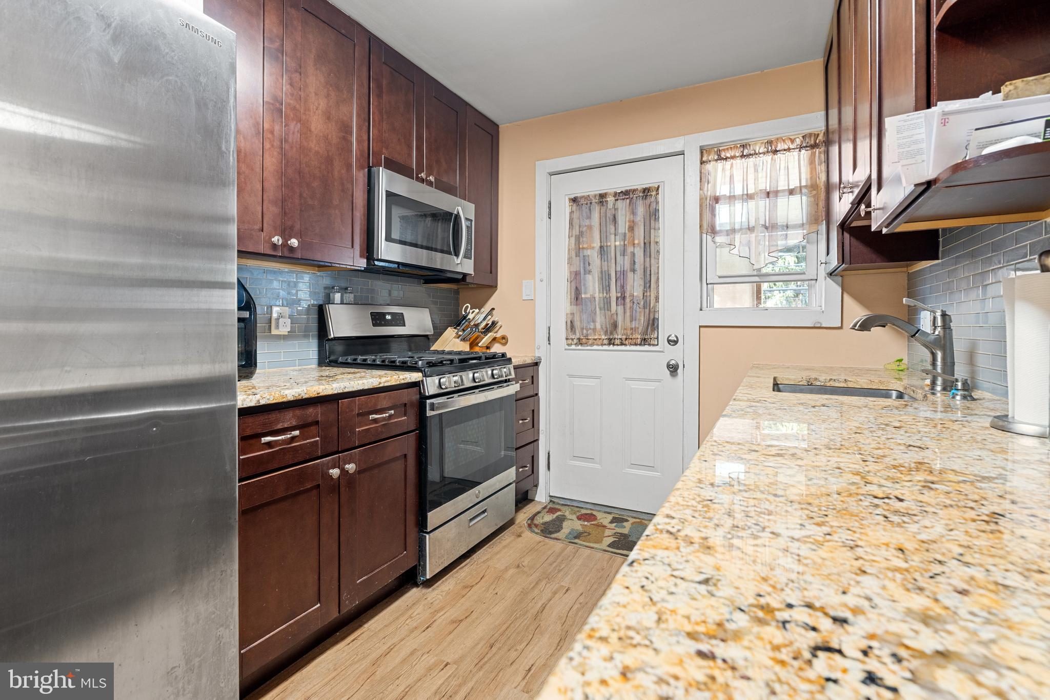 1614 Blackrock Road Swarthmore, PA 19081 - Photo 10 of 31 a kitchen with stainless steel appliances granite countertop a stove a sink and a microwave