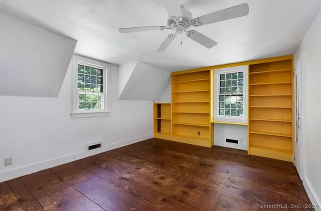 a view of room with wooden floor and ceiling fan