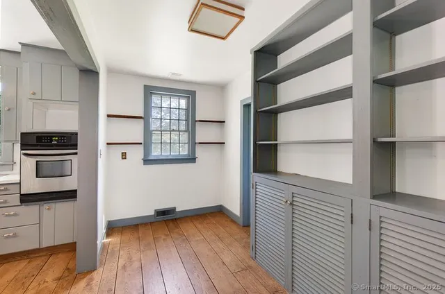 a view of a kitchen with wooden floor and cabinets