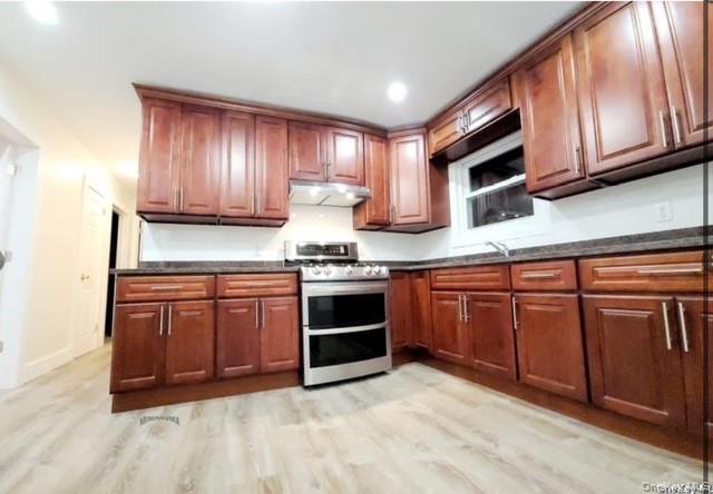 a kitchen with stainless steel appliances granite countertop a stove and a microwave