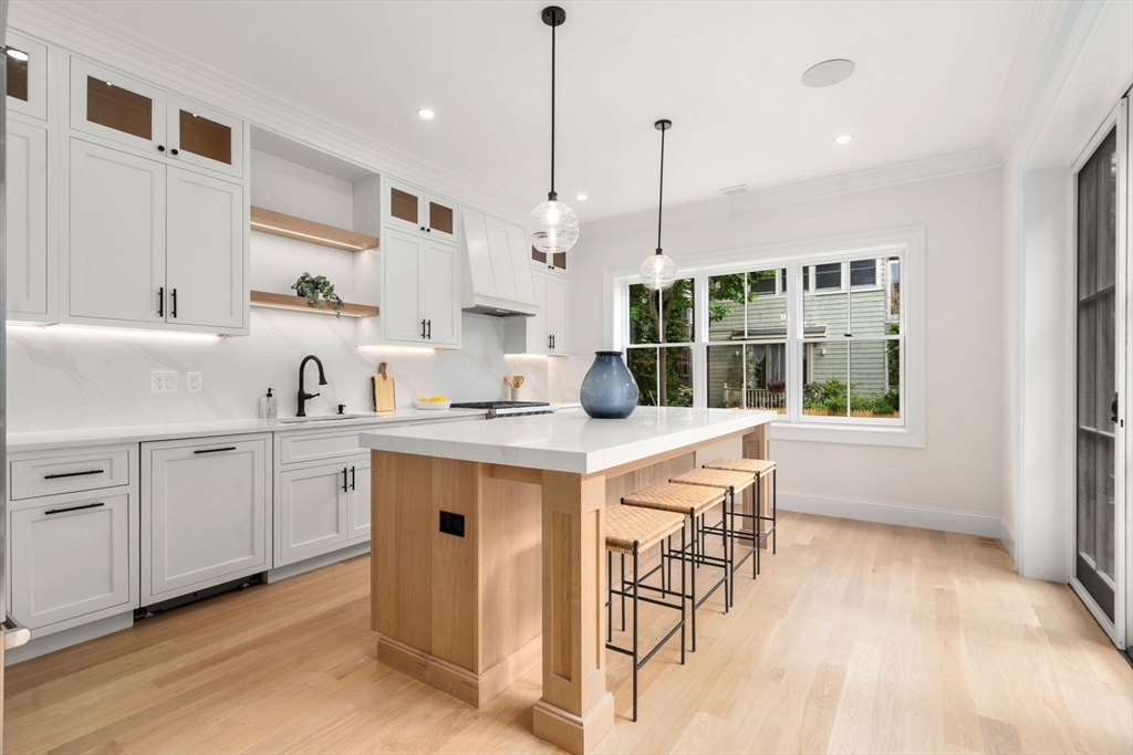 41 Waverly Street Brookline, MA 02445 - Photo 3 of 38 a kitchen with stainless steel appliances granite countertop a stove a sink and white cabinets with wooden floors