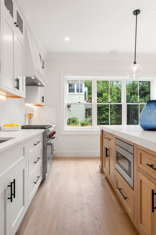 41 Waverly Street Brookline, MA 02445 - Photo 4 of 38 a kitchen with stainless steel appliances white cabinets a stove a sink and a large window