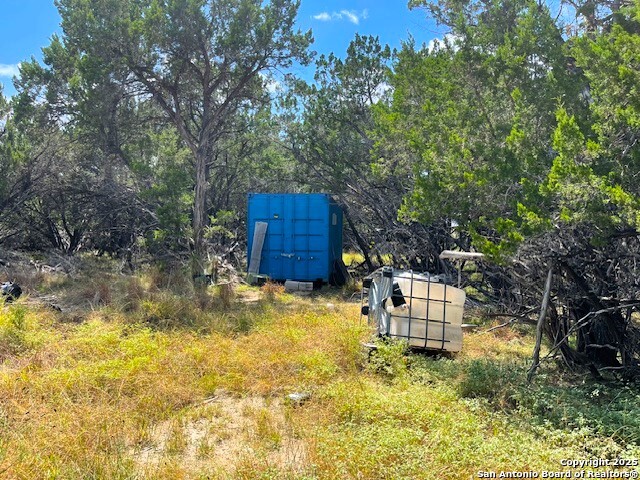 455 Spur Road Lakehills, TX 78063 - Photo 9 of 17 a backyard of a house with table and chairs