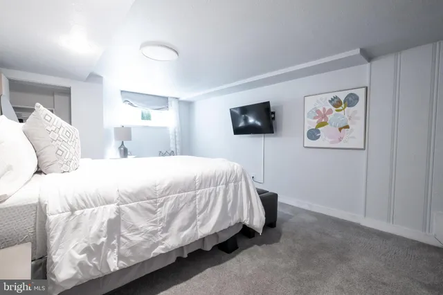 a spacious bedroom with a bed and a flat screen tv