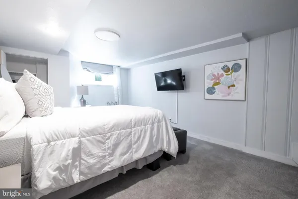 a spacious bedroom with a bed and a flat screen tv