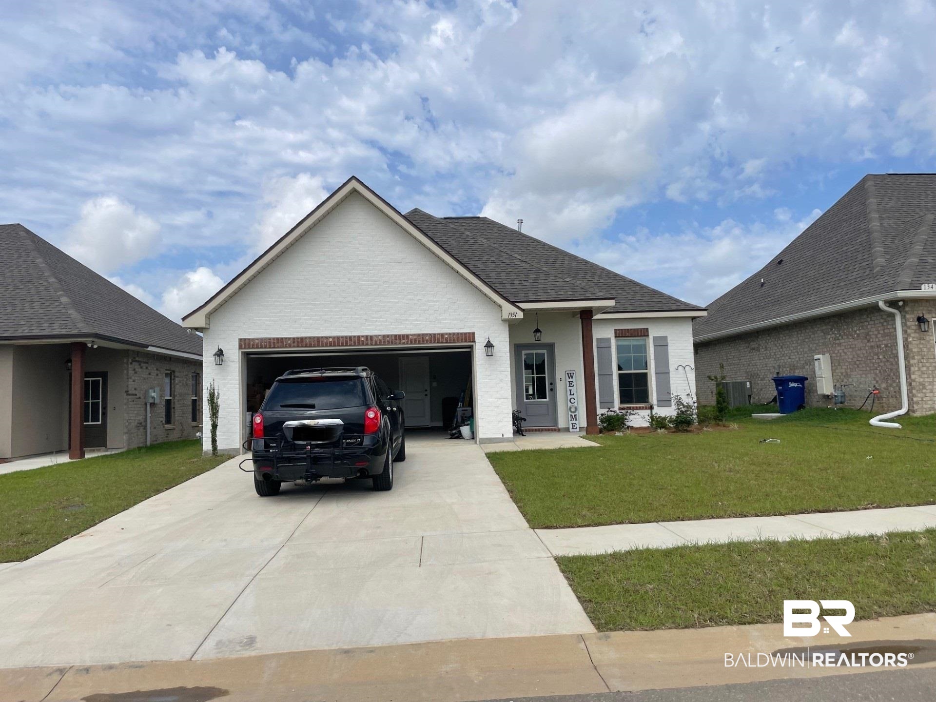 1351 Fenton Circle Foley, AL 36535 - Photo 1 of 3 Ranch-style house with concrete driveway, an attached garage, a front lawn, central AC unit, and brick siding