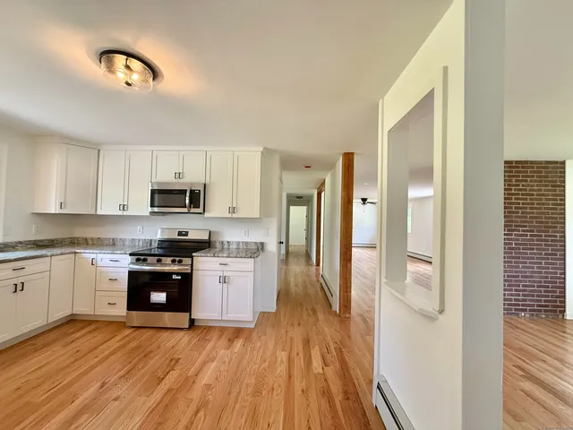 a kitchen with stainless steel appliances granite countertop a refrigerator and a stove top oven