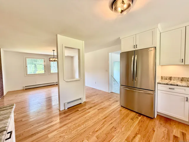 a kitchen with granite countertop wooden floors and wide window