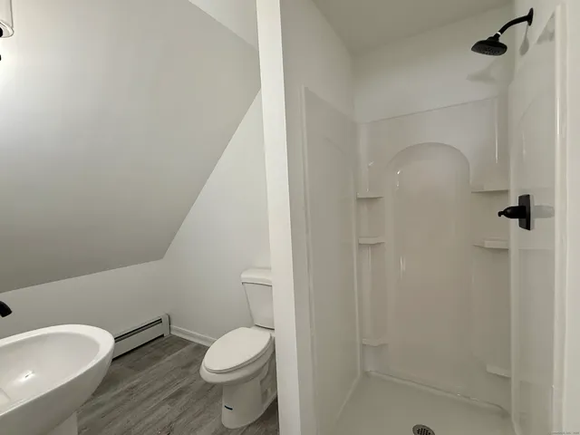a white toilet sitting next to a bath tub