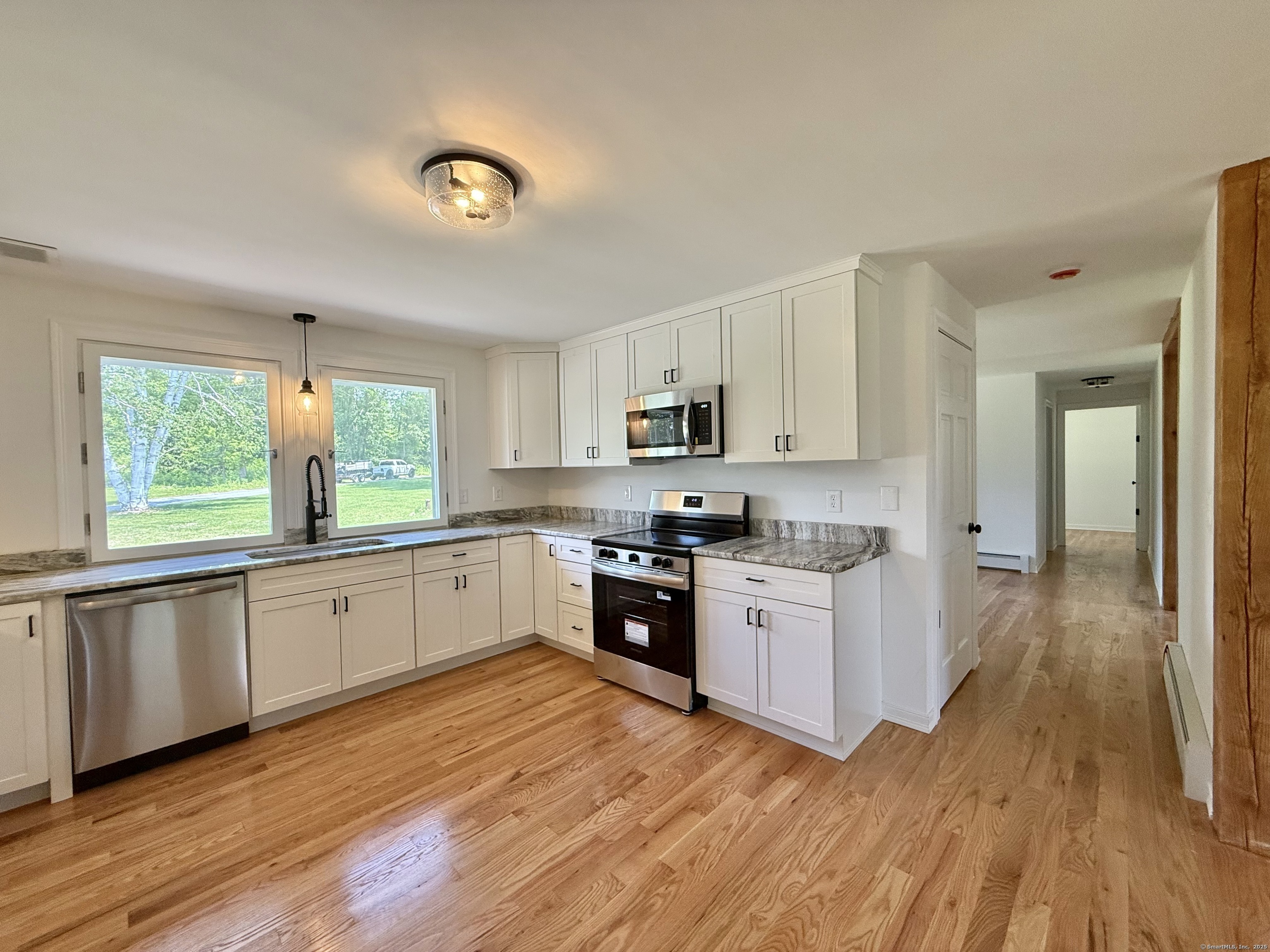 249 Wall Street Hebron, CT 06248 - Photo 10 of 28 a large kitchen with a wooden floor and stainless steel appliances