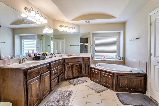 a spacious bathroom with a bathtub sink and a mirror