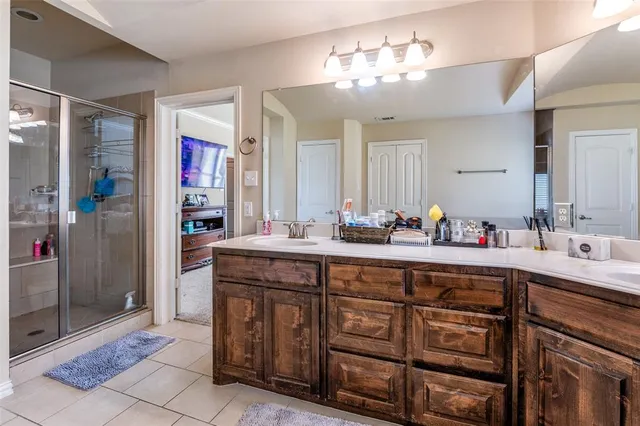 a spacious bathroom with a granite countertop sink a mirror and a shower