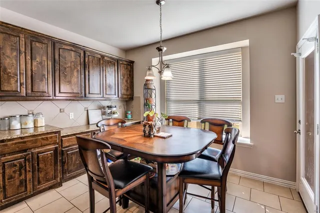 a kitchen with a dining table chairs and cabinets