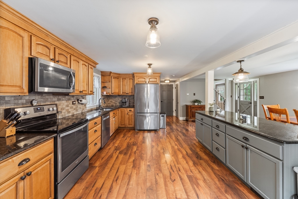 95 Ely Road Monson, MA 01057 - Photo 9 of 42 a kitchen with stainless steel appliances a stove top oven a sink dishwasher a refrigerator and white cabinets with wooden floor