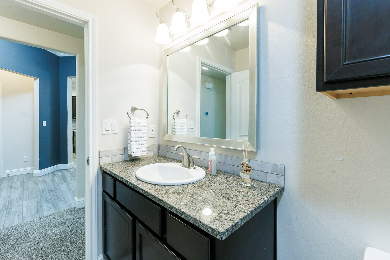 13801 Uvalde Avenue Lubbock, TX 79423 - Photo 39 of 46 a bathroom with a granite countertop sink and a mirror