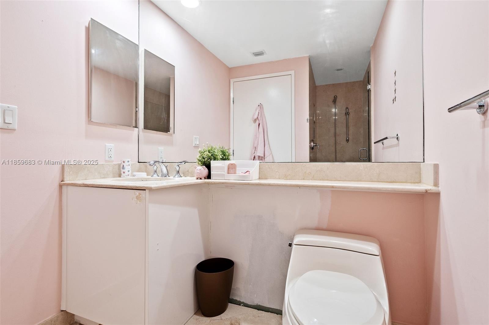 781 Crandon Boulevard, Unit 306 Key Biscayne, FL 33149 - Photo 14 of 32 a bathroom with a toilet sink and mirror